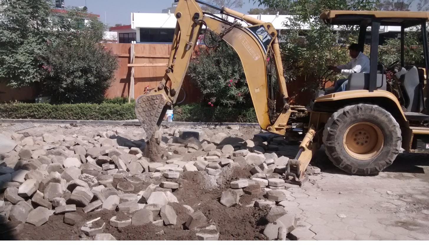 Retroexcavadora retirando adoquín para renovación de vialidad